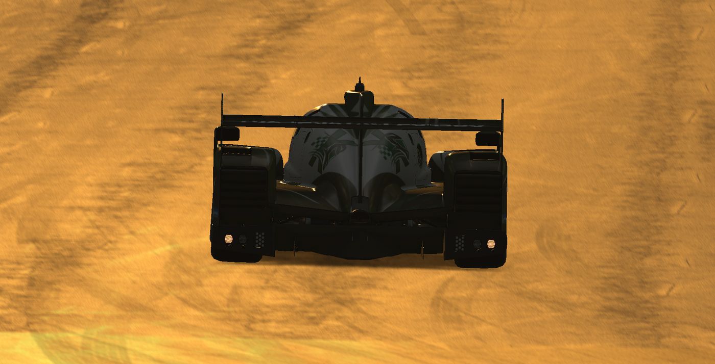 El LMP2 número 21 de frente, recortado contra un cielo naranja de atardecer.